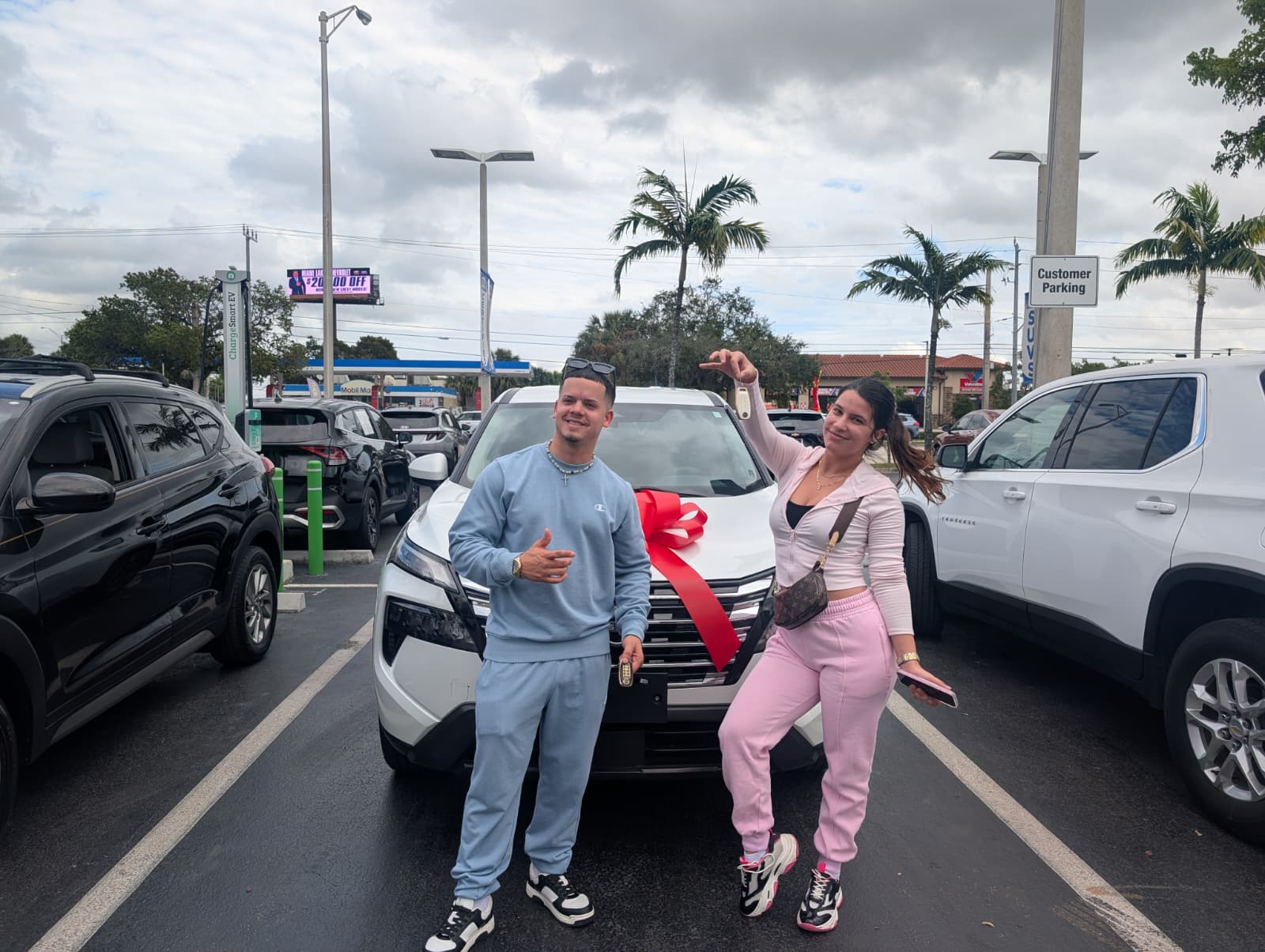 Pareja joven con carro nuevo